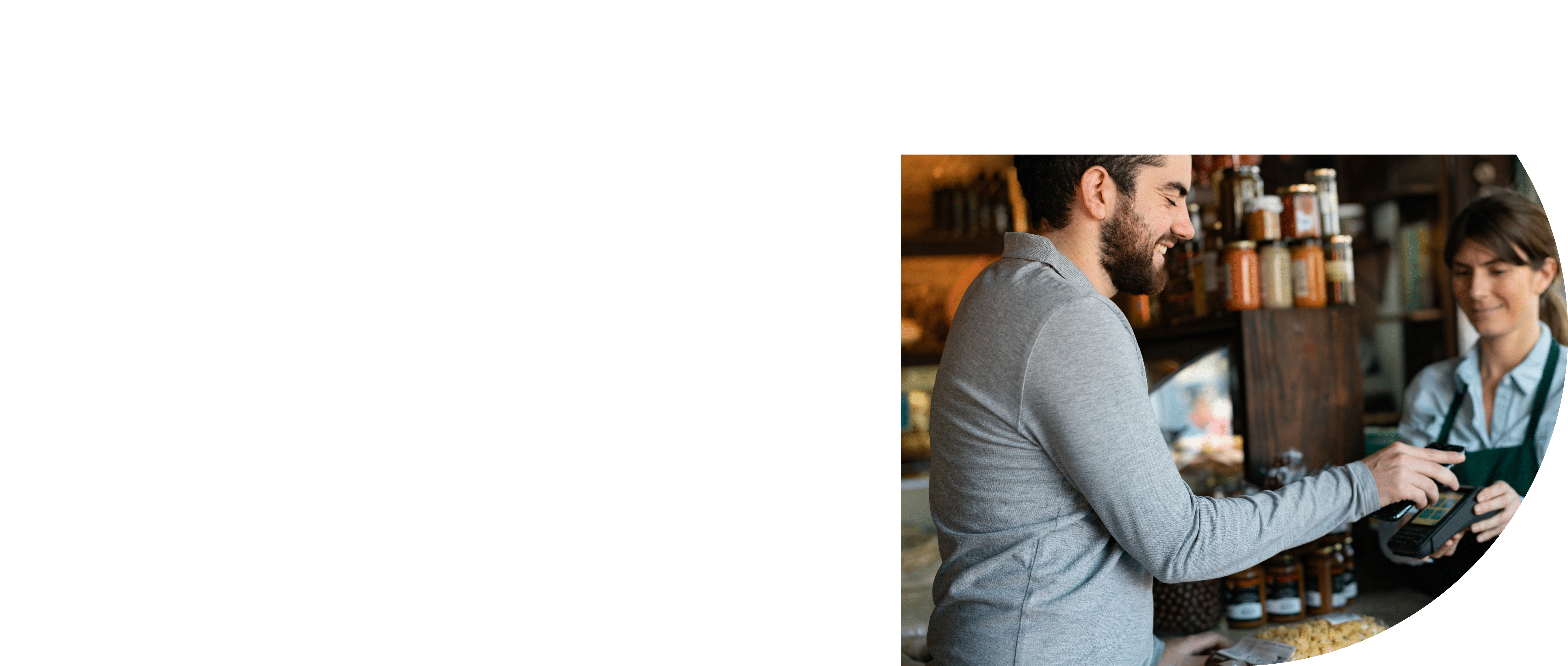 Handsome male customer at a delicatessen buying products making a contactless payment with smartphone - Small business concepts